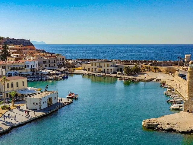Luftaufnahme einer Küstenstadt mit Hafen und Leuchtturm auf Kreta