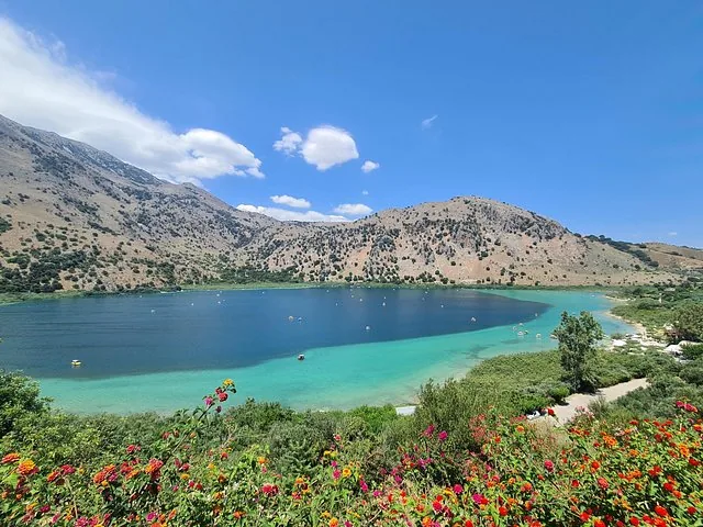 Wide view of Lake Kournas with colorful flowers in the foreground
