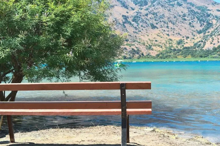 Eine Holzbank am Ufer des Kournas-Sees mit Blick auf das Wasser