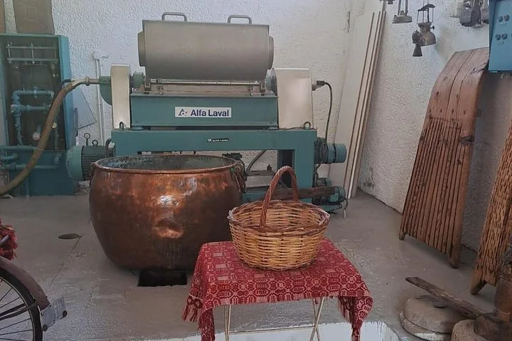 Historische Olivenölpresse mit großem Kupferkessel und Korb