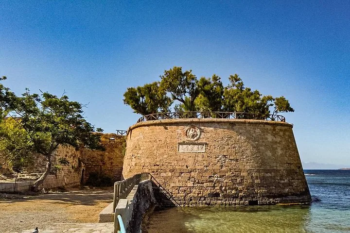 Historische Steinbastion am Hafeneingang, auf der Bäume wachsen